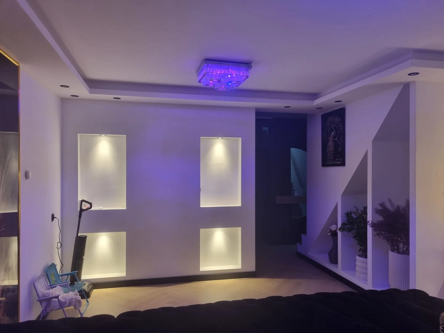 Tv-wand en plafond met paarse verlichting