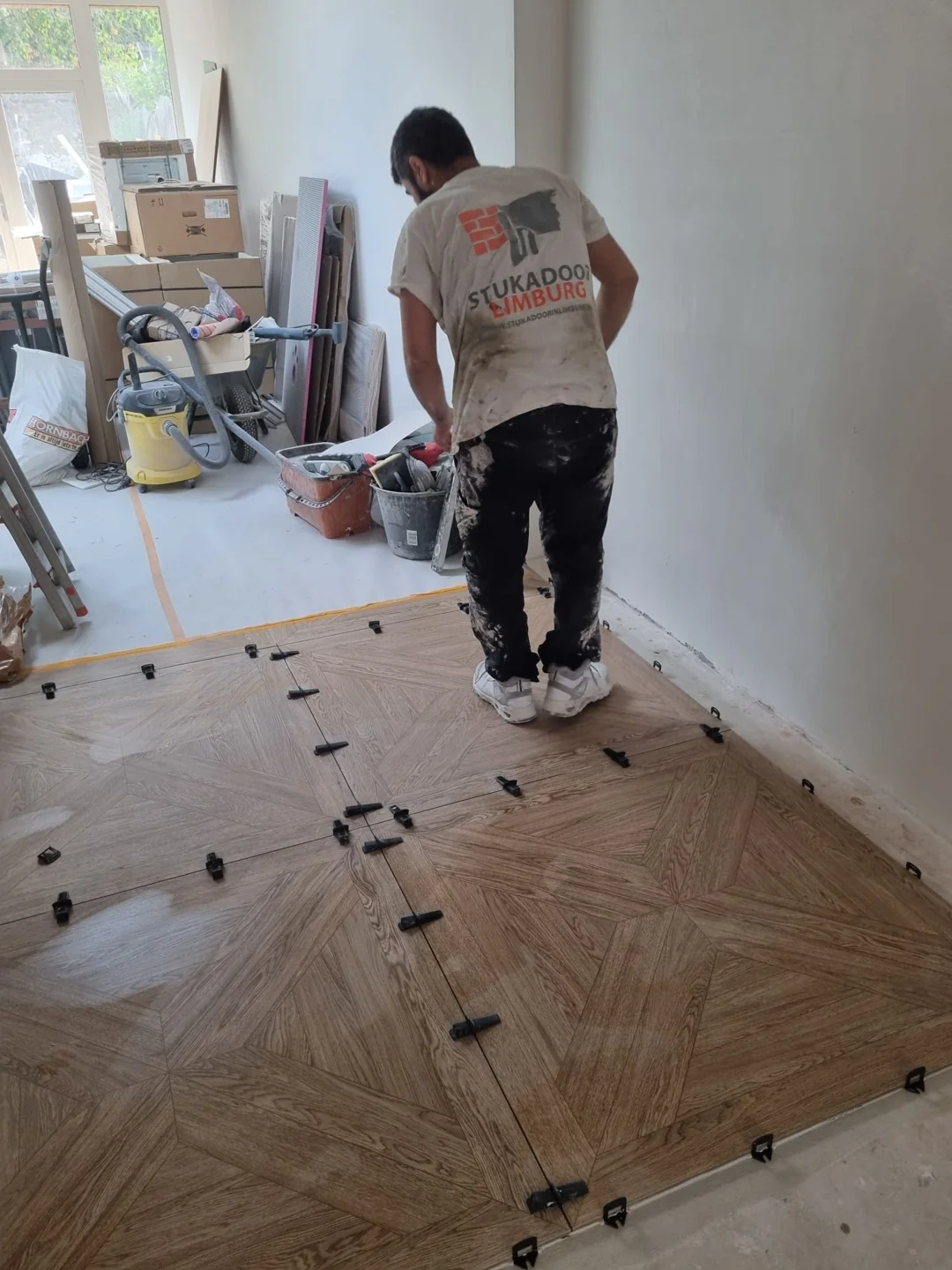 Medewerker bij vloer met houtlook tegels