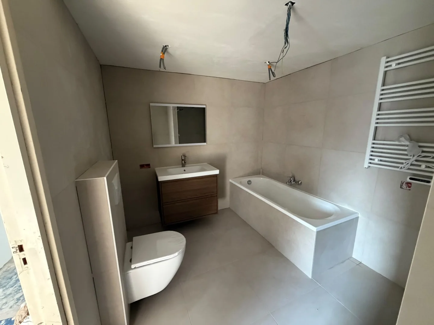 Breed badkamerbeeld met bad, meubel, wand- en vloertegels