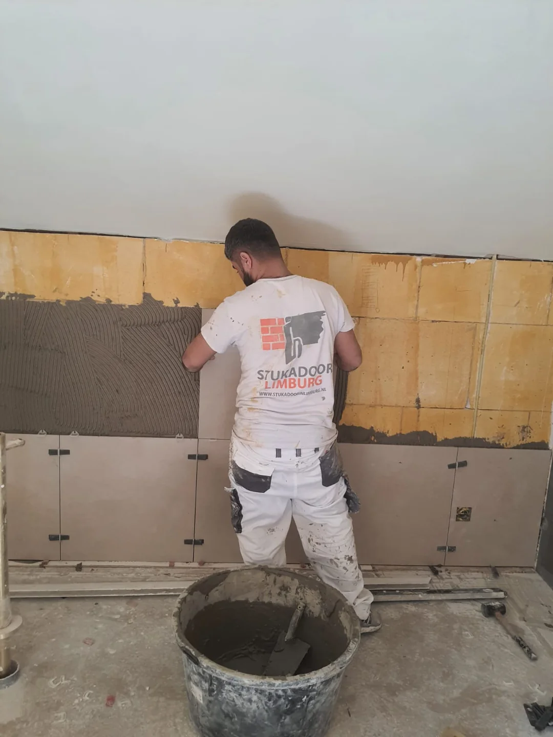 Medewerker bij wandtegelplaatsing